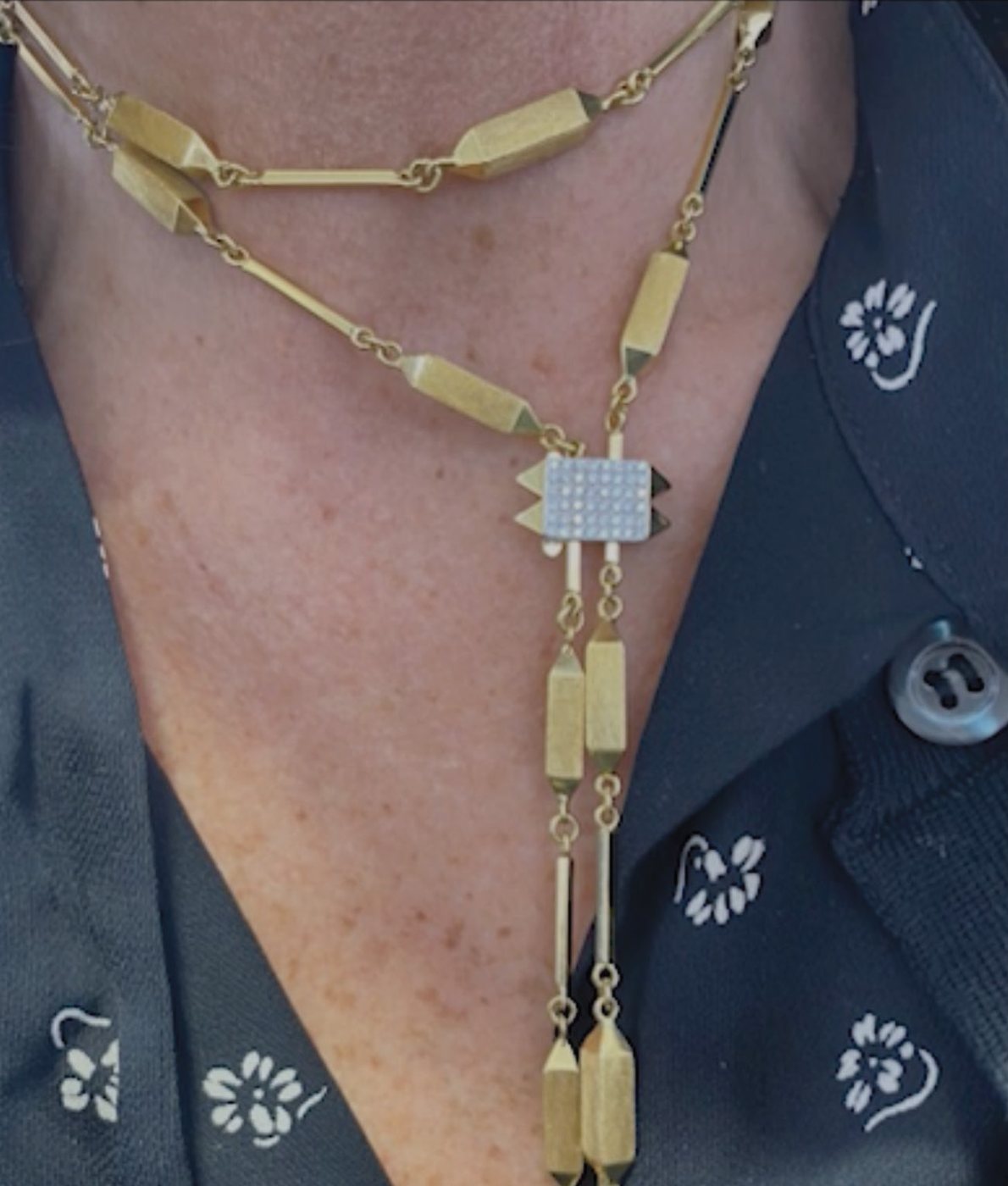 The long gold necklace, worn